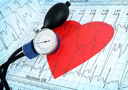  A blood pressure monitor on a printout of a heart and heartbeat graph. (stock image)