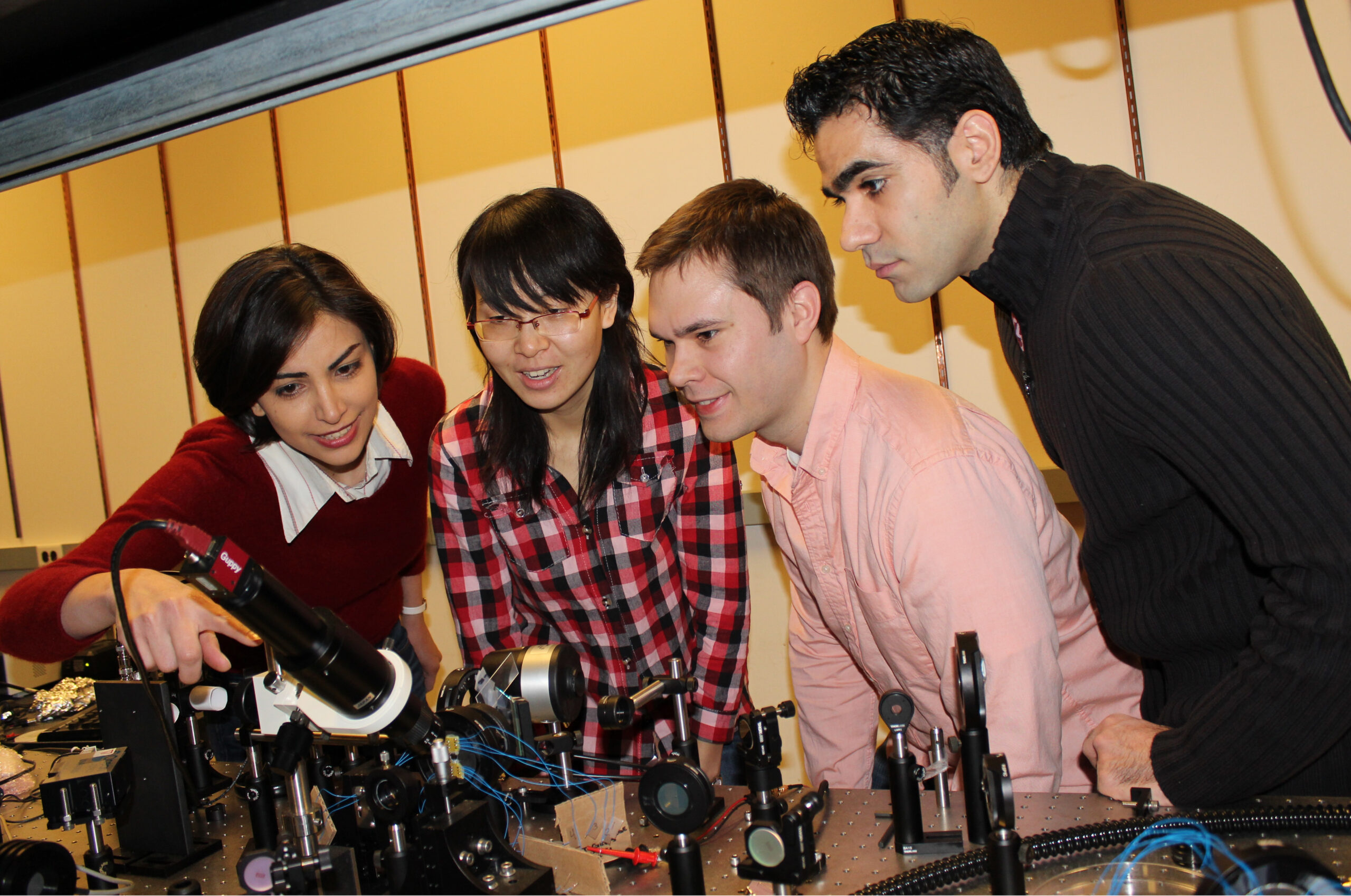 Mona Jarrahi, assistant professor of electrical engineering and computer science, and members of the research team that recently developed a super-sensitive terahertz source and detector system. Pictured are Ning Wang and Christopher Berry, doctoral students in electrical engineering and computer science, and Mohammad Reza Hashemi, a postdoctoral researcher in the same department. Photo courtesy of Mona Jarrahi