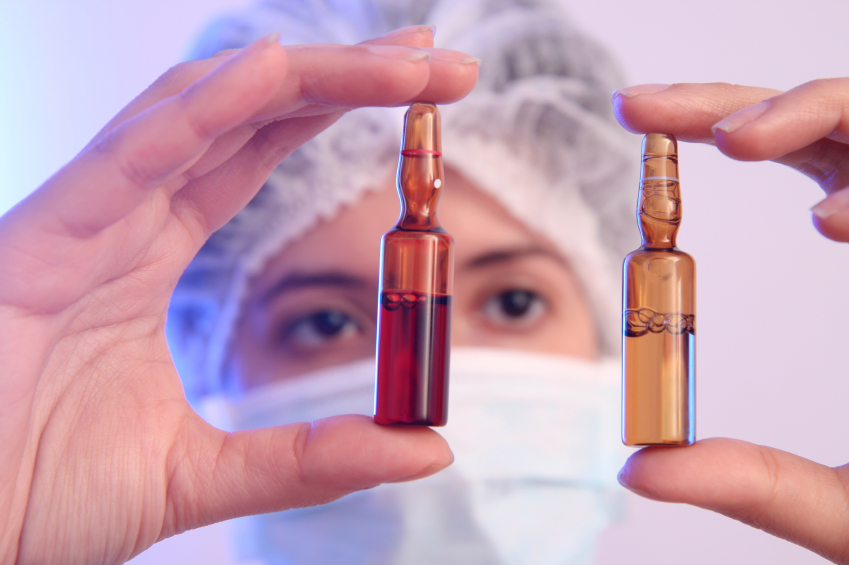 A researcher compares two vials of medication. (stock image)