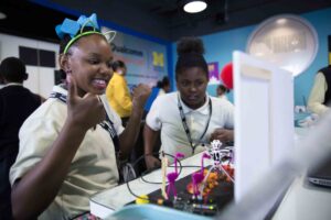 A fourth grader from Coleman A. Young Elementary School reacts to seeing her Arduino diorama project move for the first time as part of the Qualcomm Thinkabit Lab in the Michigan Engineering Zone. Image credit: Evan Dougherty