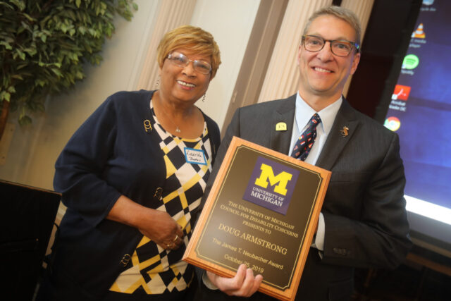Photo of Laurita Thomas, former associate vice president for human resources, presenting the 2019 James T. Neubacher Award to North Star Reach CEO Doug Armstrong at a ceremony Oct. 25.