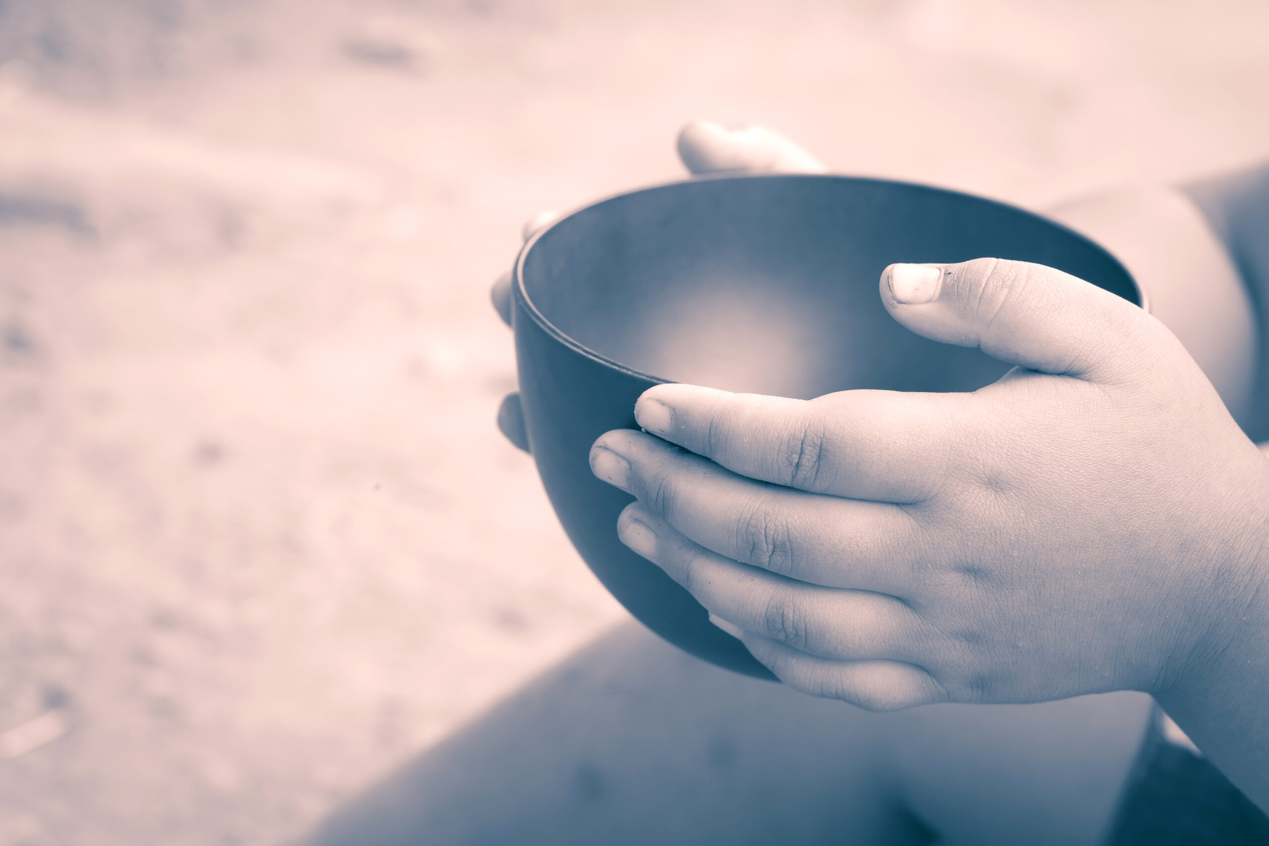 Image of a child holding an empty bowl.