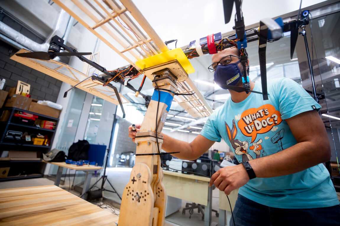 Photo of Akshay Mathur, a robotics Ph.D. student, testing a biplane model.