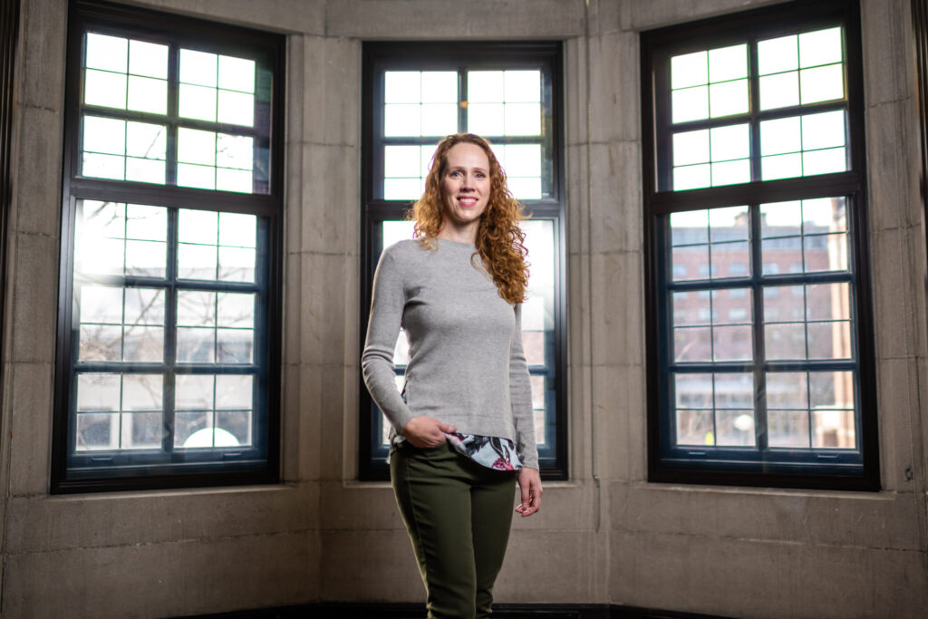 Laura Power standing in front of windows.