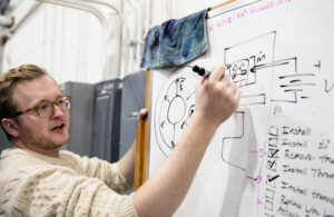 Aerospace engineering Ph.D candidate Thomas Marks explains how the new Hall thruster works at the PEPL lab on University of Michigan’s North Campus. Image credit: Marcin Szczepanski/Lead Multimedia Storyteller, University of Michigan College of Engineering