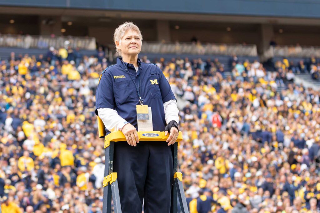 Lynn Hansen, one of first female members of Michigan Marching Band, conducting at U-M 2022 Homecoming. Image courtesy: Lynn Hansen