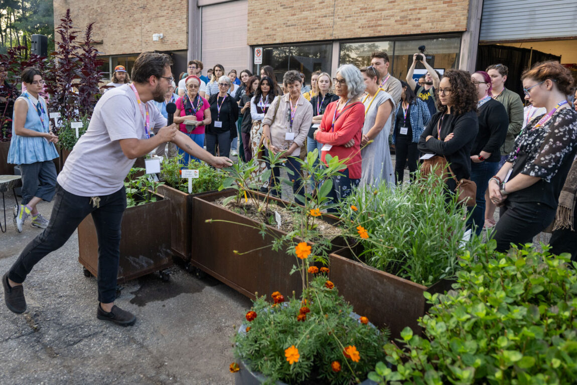 Photo of Nicholas Dowgwillo pointing out some of the plants being grown at the Stamps Sustainable Materials & Color Garden