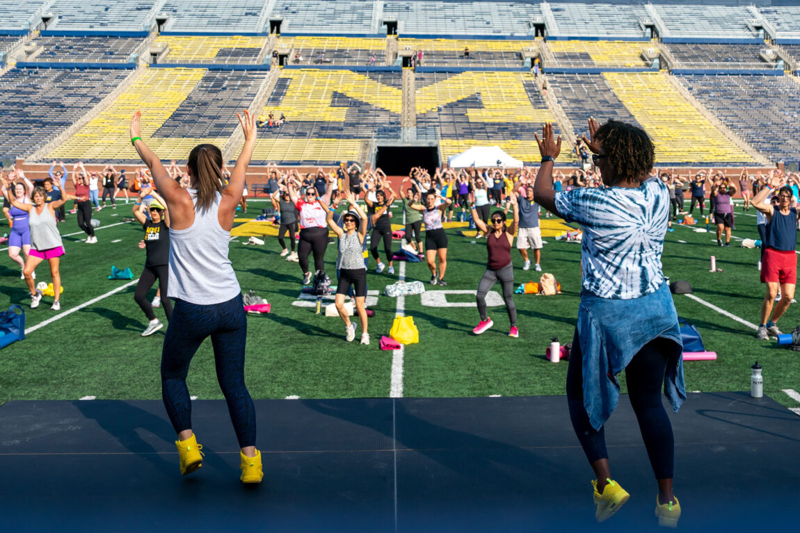 A photo of two instructors leading a Zumba class at Michigan Stadium
