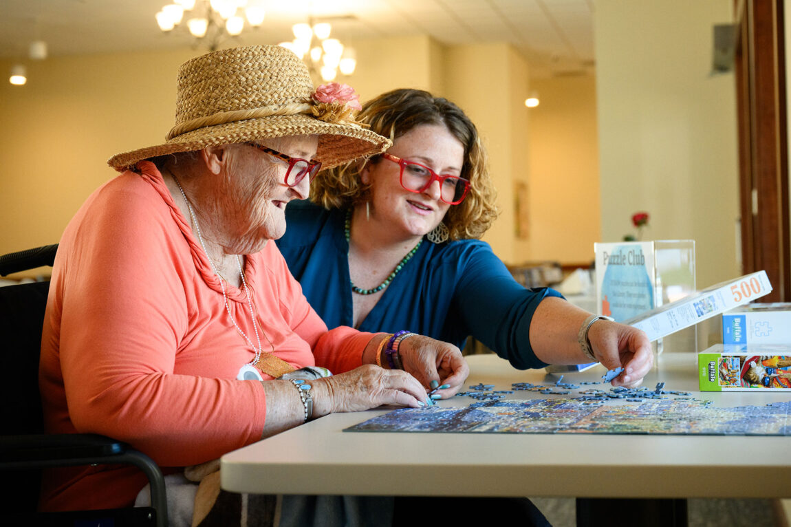 Photo of Mary Schlitt and her mother, Mary Sergent, working together on a jigsaw puzzle.