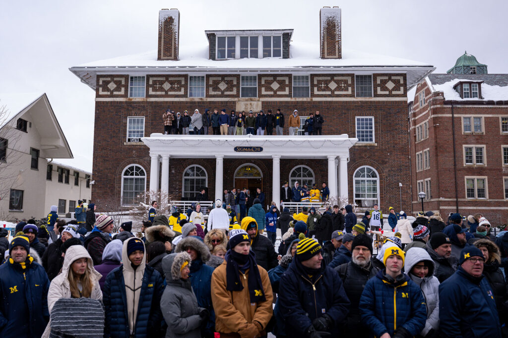 Fans lined up in front of — and on — the Sigma Chi fraternity house to enjoy the parade.