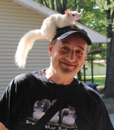 A photo of a man with a squirrel on his head