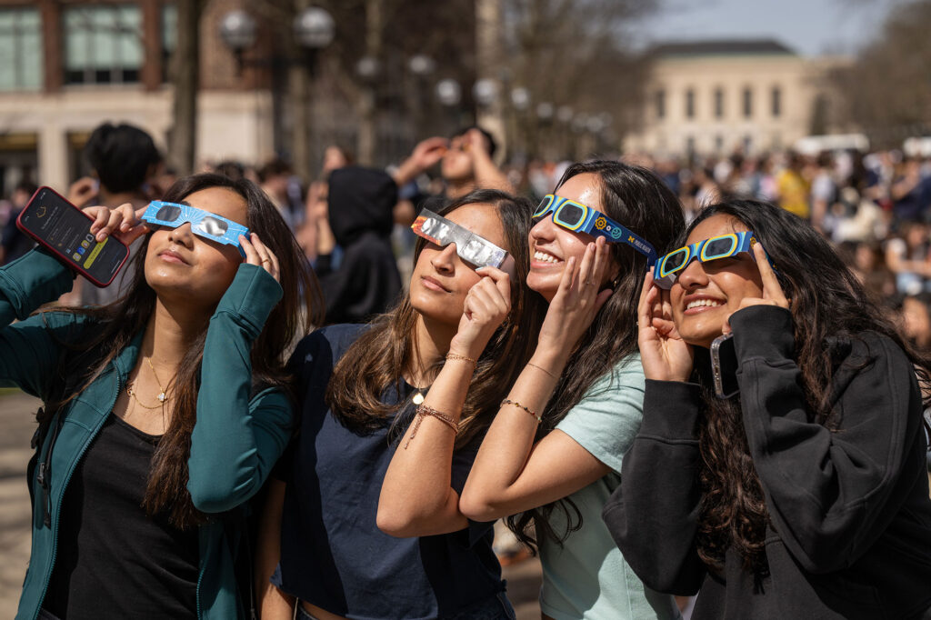 Photo of four women looking at the eclipse