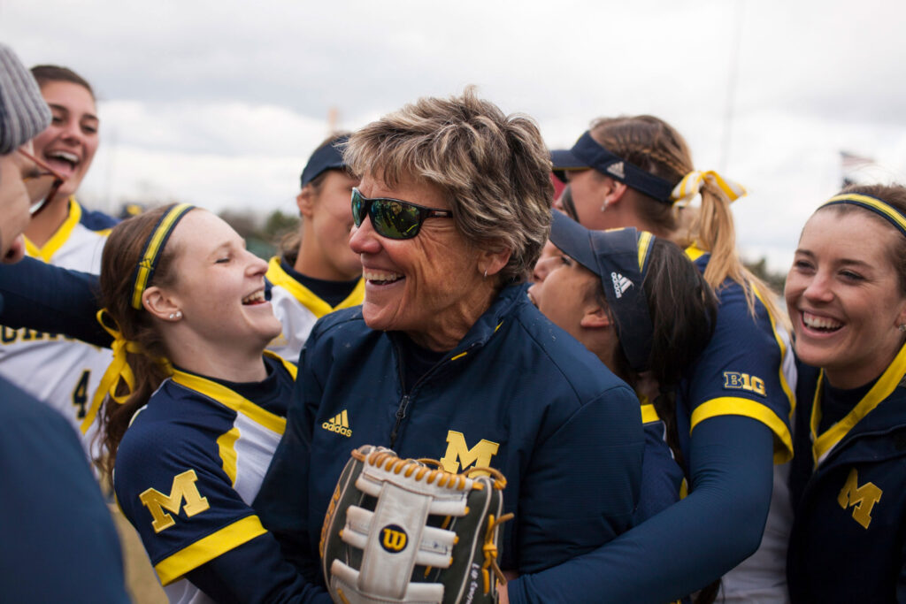 A photo of Carol Hutchins and softball players celebrating