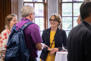 Provost Laurie McCauley talks with a man at New Faculty Orientation