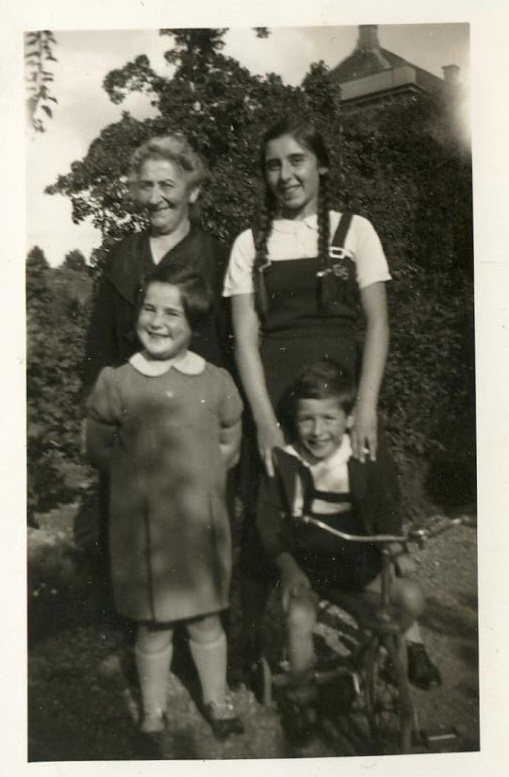 Photo of an elderly woman with three grandchildren