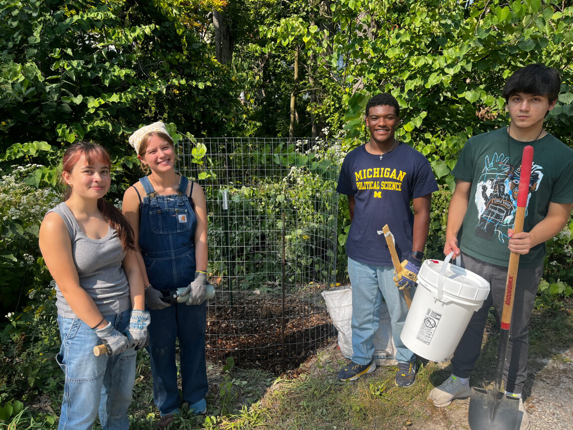 A photo of four students planting trees