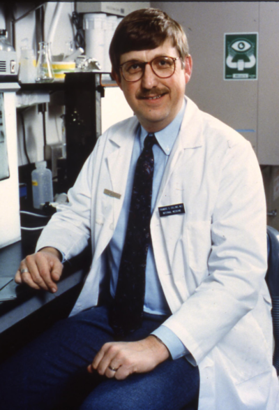 A photo of a scientist sitting in a lab coat