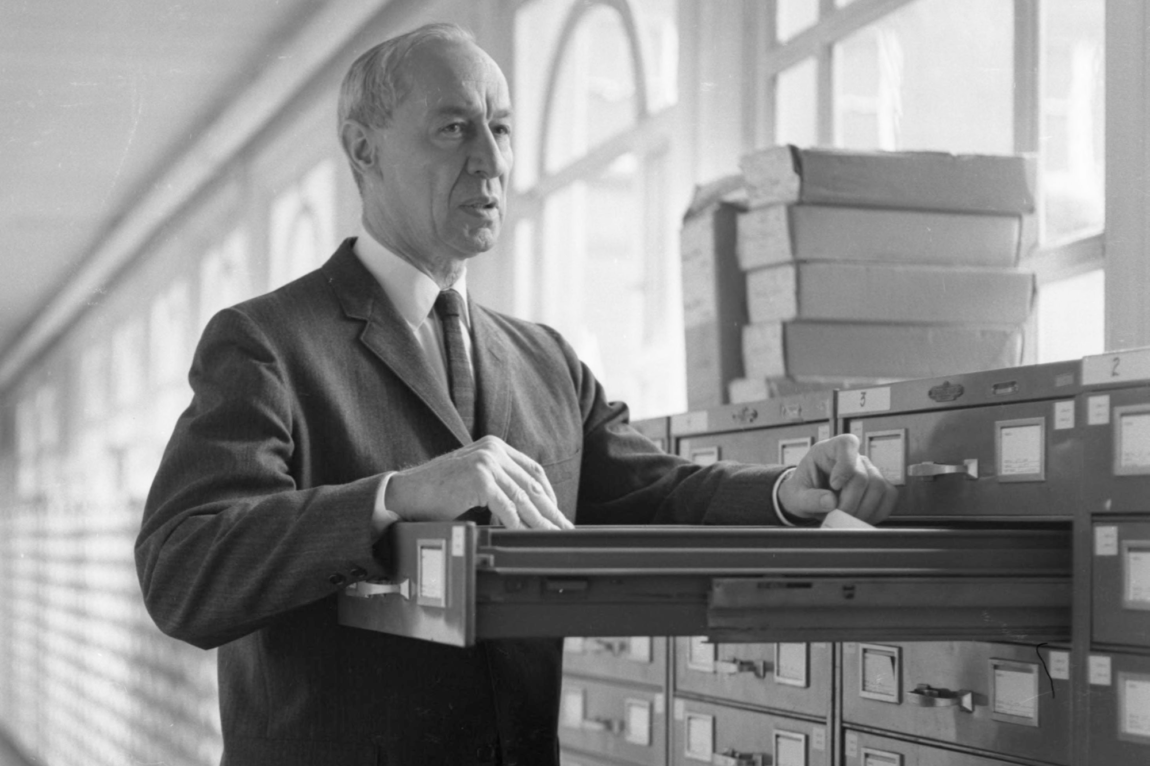 A photo of a man standing at a file cabinet