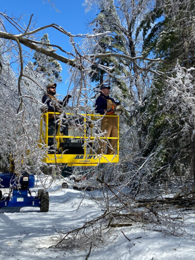 A photo of people cleaning up debris from an ice storm