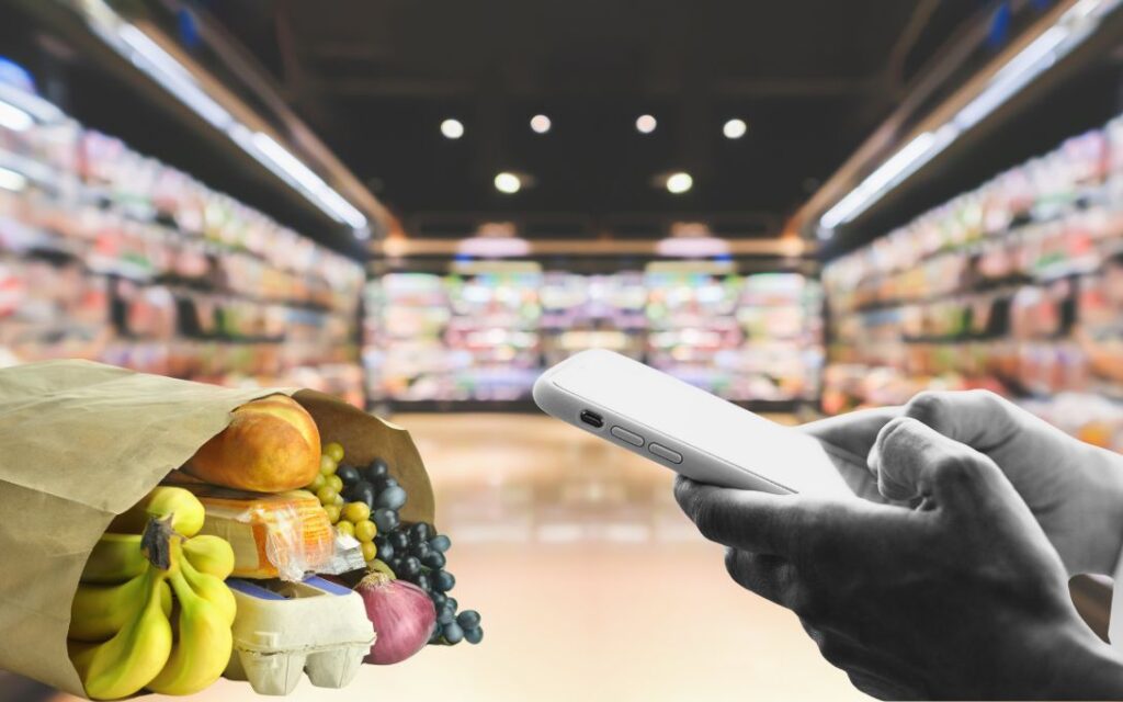 Concept photo of a person using their smartphone at the grocery store. Image courtesy: U-M Poverty Solutions