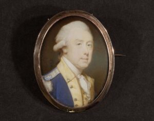 Thomas Gage, oval miniature portrait painted by artist Jeremiah Meyer (1735-1789) on ivory, rose gold rim, pin back, necklace chain holes, cobalt blue backing, ca. 1785–1787. Thomas Gage wears the uniform of the 11th Light Dragoons, the regimental coat indicating his colonelcy (held between 1785 and his death in 1787). Gift of Benjamin and Bonnie Upton, and Margaret Trumbull. Image courtesy: University of Michigan William L. Clements Library.