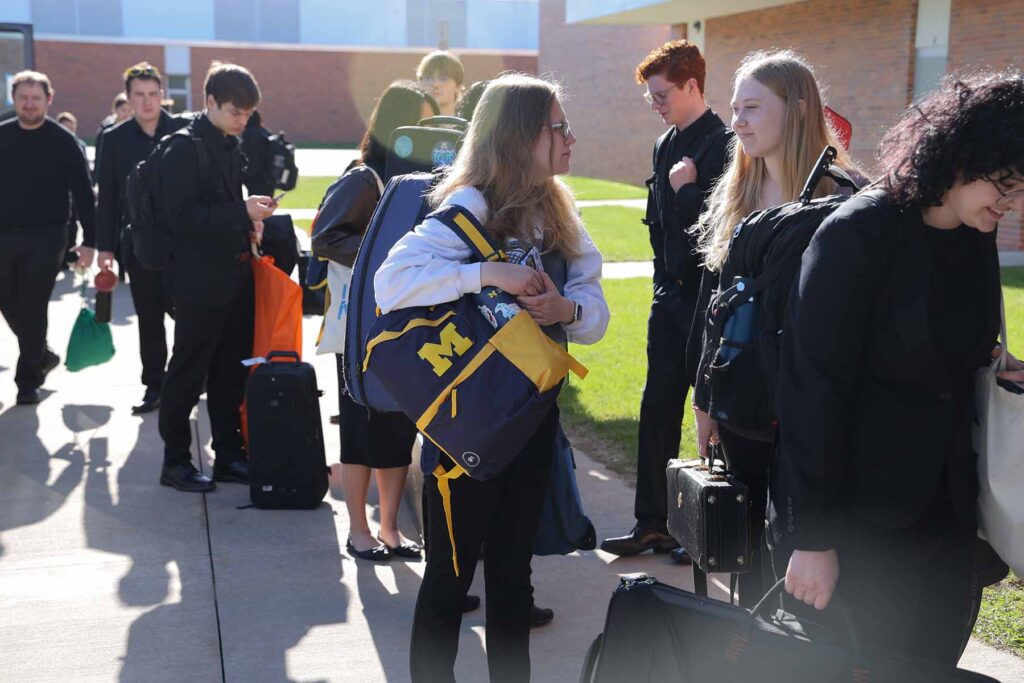 University of Michigan students and members of the Symphony Band arrive at H. H. Dow High School for clinics and a concert performance.
