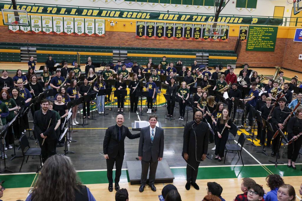 Jason Fettig, Stephen DeRees, music education teacher at H. H. Dow High School, and DaJuan Brooks, U-M doctoral student, with the combined college and high school student band.
