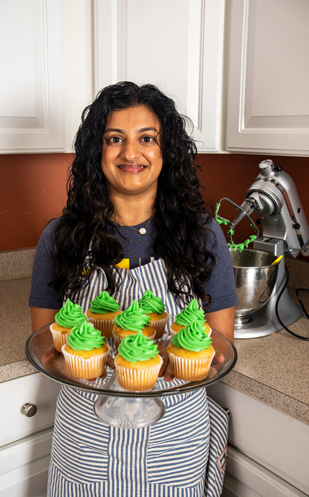 A photo of Rujuta Umarji with green cupcakes she baked

