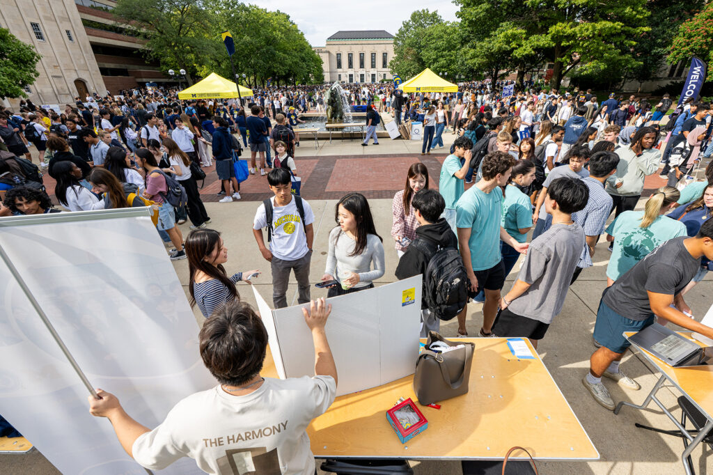 People gather around tables set up outside