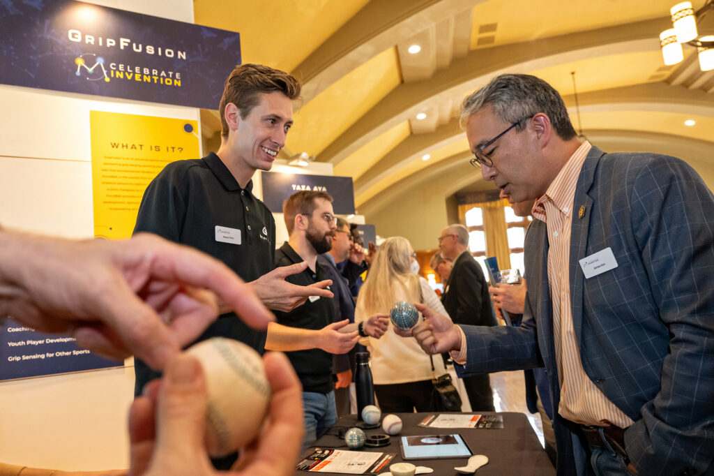 Grip Fusion co-founder Mason Ferlic, left describes his innovation to James Kim, a retired technology engineer during Celebrate Invention. Grip Fusion is an AI-powered sports technology company pioneering grip-sensing sporting equipment which provides real-time bio,mechanical feedback.