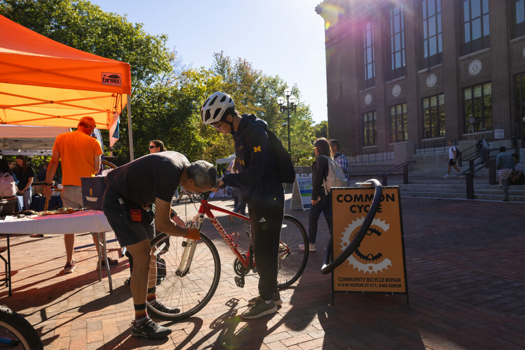 A bike is repaired while the owner holds it up