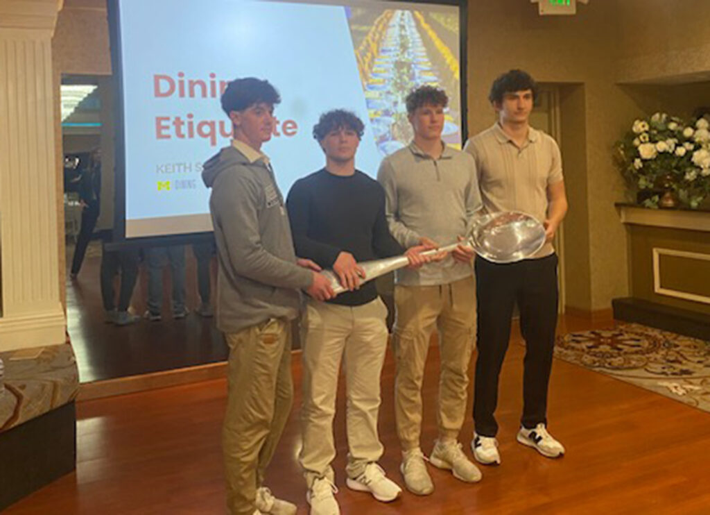 High school students pose with Soster’s oversized soup spoon. 