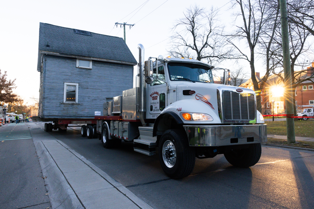 A trailer hauls a house down a street