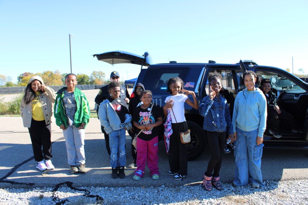 Kids posing in front of the cop and SUV. Image credit: Juan Ochoa