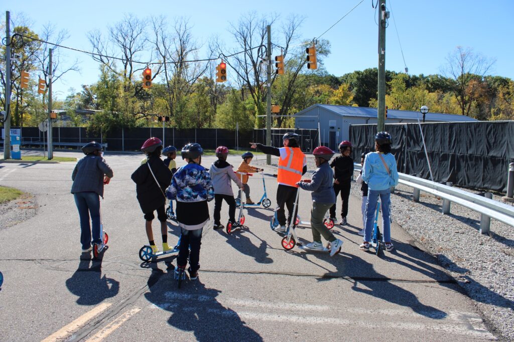 Student volunteer Dylan Hogan is explaining safety tips for crossing intersections and indicating the direction they are headed. Image credit: Juan Ochoa