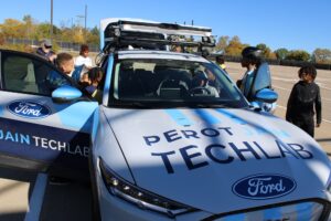 Students looking into the autonomous vehicle and asking questions about the equipment. Image credit: Juan Ochoa