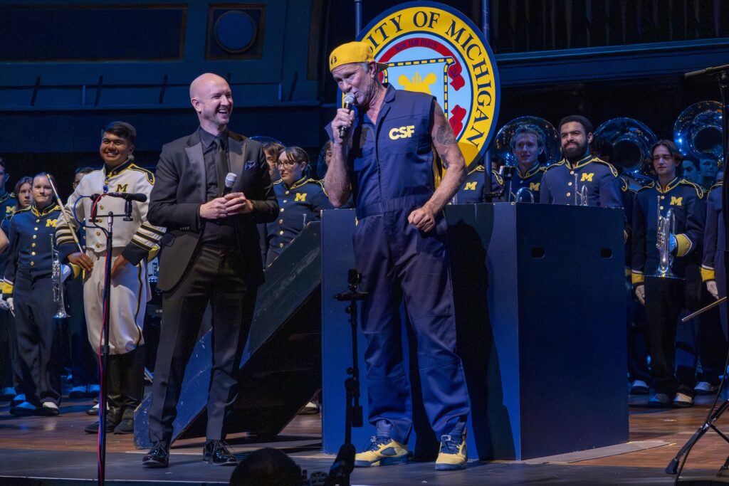 Chad Smith speaks with Jason Fettig (left), professor of music and director of bands at the University of Michigan, about the Joan and Curtis Smith Scholarship established by the Chad Smith Foundation for a future student at the University of Michigan School of Music, Theatre & Dance. The scholarship was announced during the Band-O-Rama concert at Hill Auditorium in Ann Arbor, Michigan, November 2, 2025. Image credit: Robert Coelius, University of Michigan