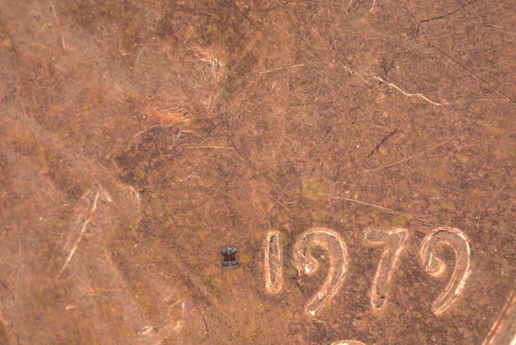 The robot is a tiny rectangle, just slightly wider than the 1 in 1979 on the penny, and about a third as tall.