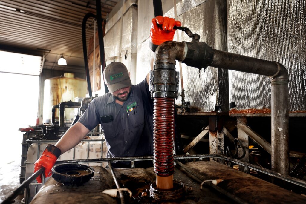 Alex Ritter, vice president of operations and co-owner of Thumb BioEnergy in Sandusky, Mich., demonstrates how his company cleans fry oil before it is converted into biodiesel. Ritter's company recycles fry oil collected from restaurants throughout Michigan. Most of his product is currently sold out of state, but Ritter provided insight on how to create demand in Michigan. Image credit: Brenda Ahearn, Michigan Engineering.