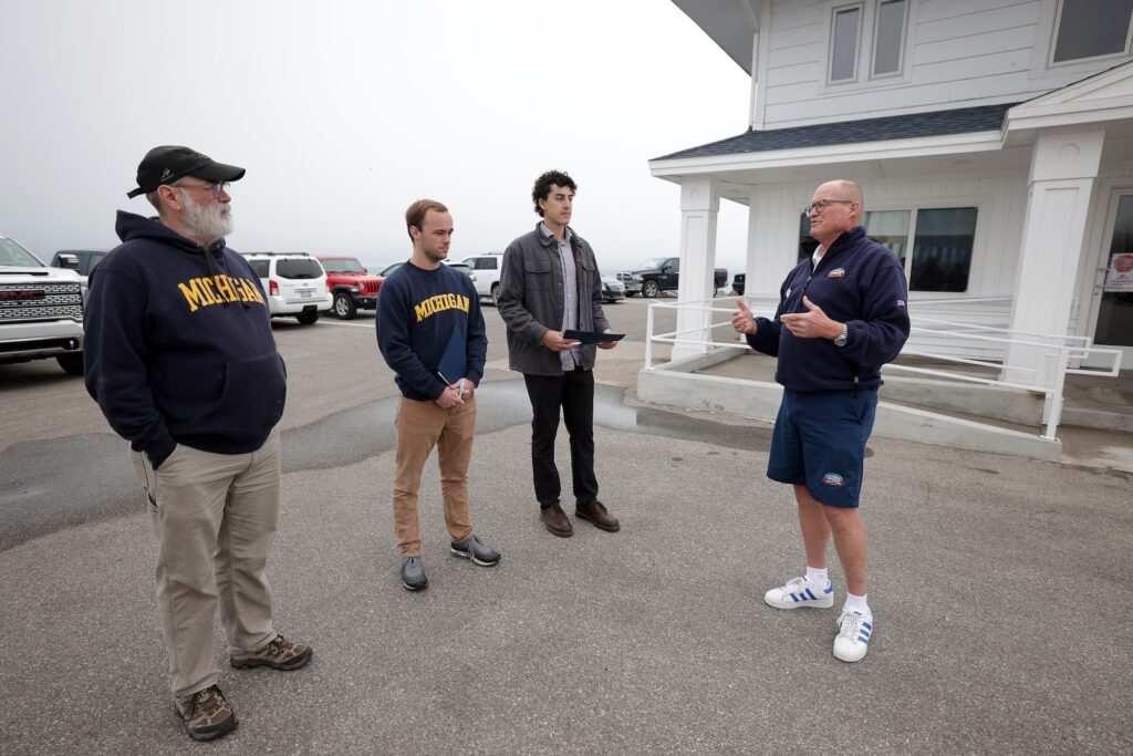 Chris Shepler (outer right), president of Shepler's Ferry Service meets with Geoff Lewis (outer left), a research specialist lead in the U-M School for Environment and Sustainability's Center for Sustainable Systems, Owen Baldwin (center left), a Master’s student in environmental engineering and sustainable systems, and Logan Cox (center right), a Master's graduate in naval architecture and marine engineering. They discussed the feasibility of electric ferries, alternative fuels and the business's needs and challenges. Image credit: Brenda Ahearn, Michigan Engineering.