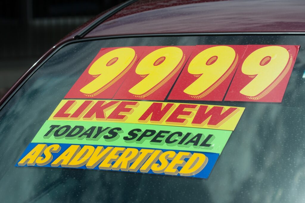 Price sticker on used car lot. Image credit: Adobe Stock