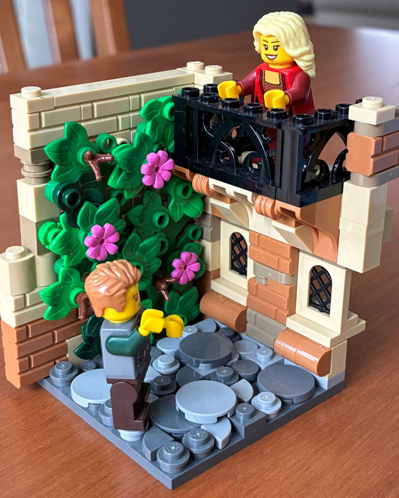A LEGO display showing a balcony with a LEGO figure looking down to another LEGO figure