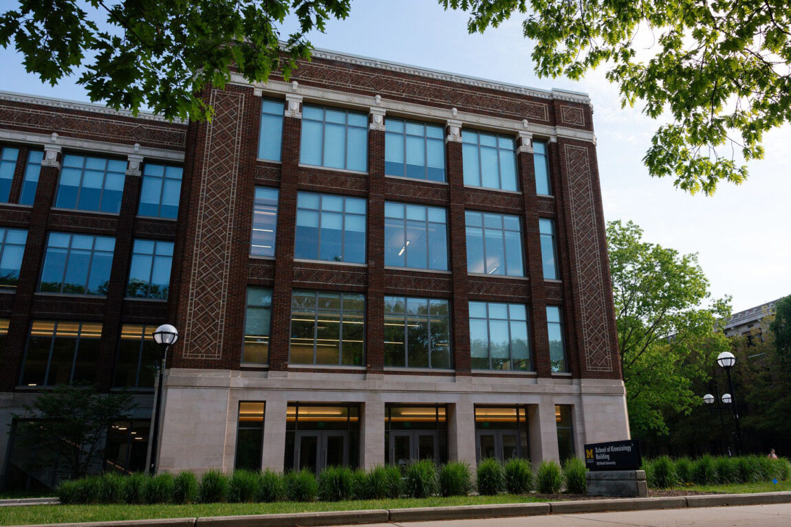 A four-story building, the top three with brick and the bottom with stone