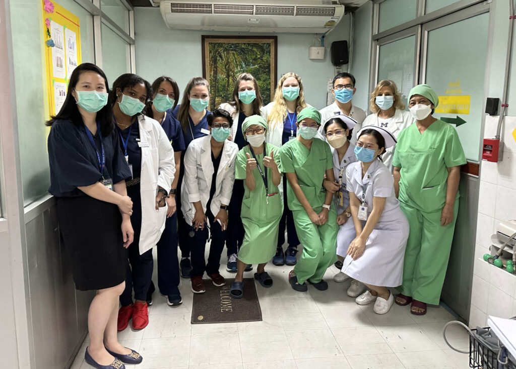 Group of students posing in a hospital setting with doctors