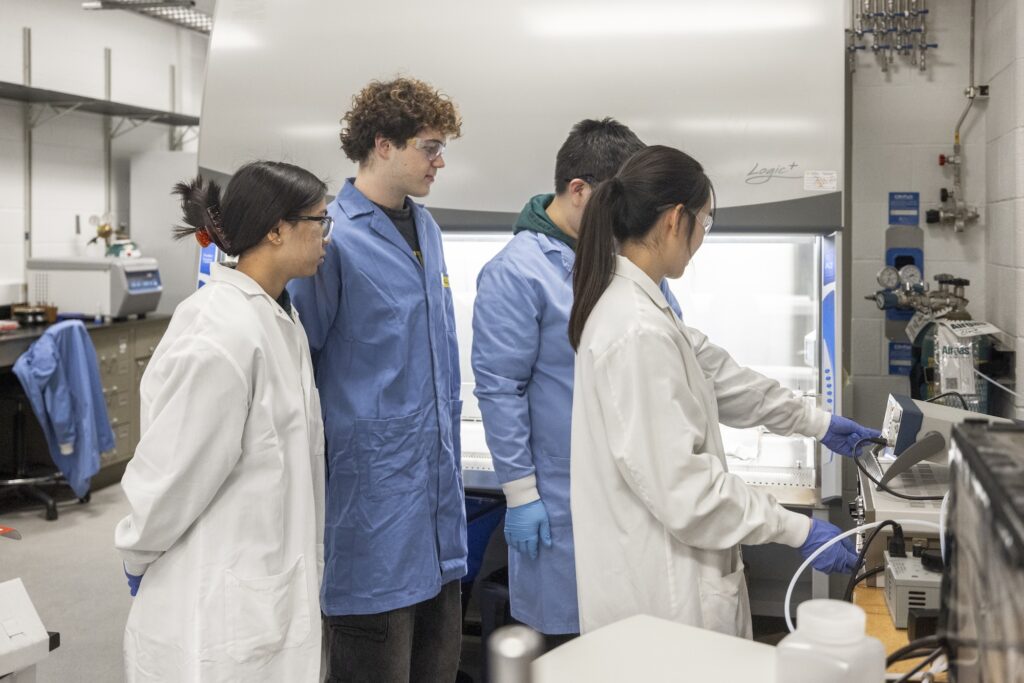 Zari Bruch, undergraduate aerospace engineering student, Justin French, undergraduate environmental engineering student, Zhenyu Ma, research fellow in civil and environmental engineering, and Emily Hong, PhD precandidate in civil and environmental engineering, observe the plasma machine at Herek Clack’s lab at the G.G. Brown Laboratory on North Campus at the University of Michigan. Image credit: Gabi Iriarte/Michigan Engineering, Communications & Marketing