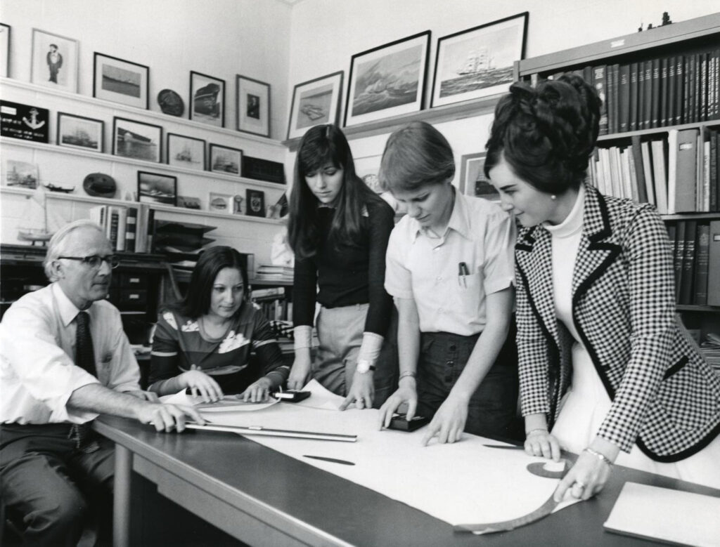 Female engineering students meet with a professor circa 1974