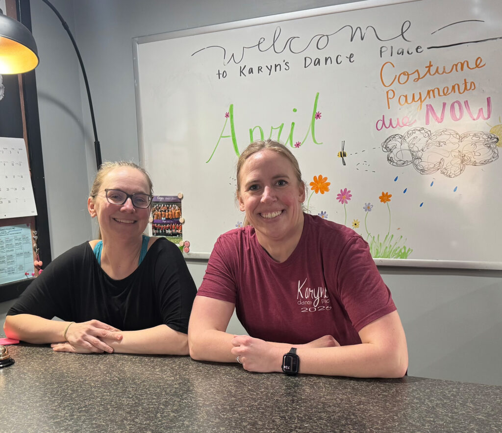 Weaver (with her childhood friend Leah, sitting at the front desk at Karyn’s Dance Place.
