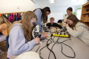 Students at Daycroft School look at microplastics through a microscope. Image credit: Jeremy Marble, University of Michigan News