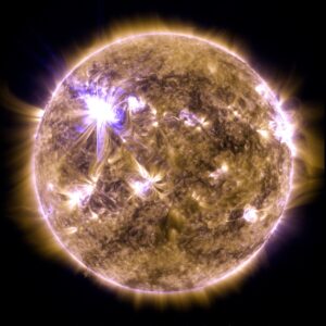 The sun looks like a fiery yellow ball with flashes and loops of blue and white light.