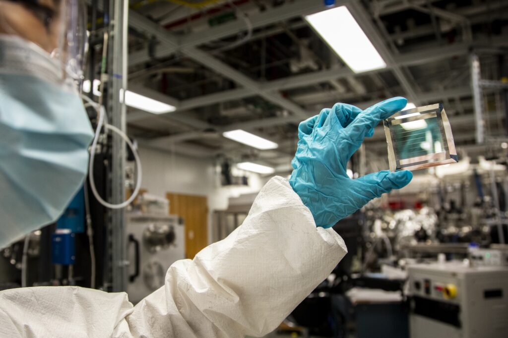 Xinjing Huang, a doctoral student in Forrest’s lab, holds a solar cell module with 40% transparency, based on the formula with an estimated 30-year lifetime. Image credit: Robert Coelius, University of Michigan Engineering.